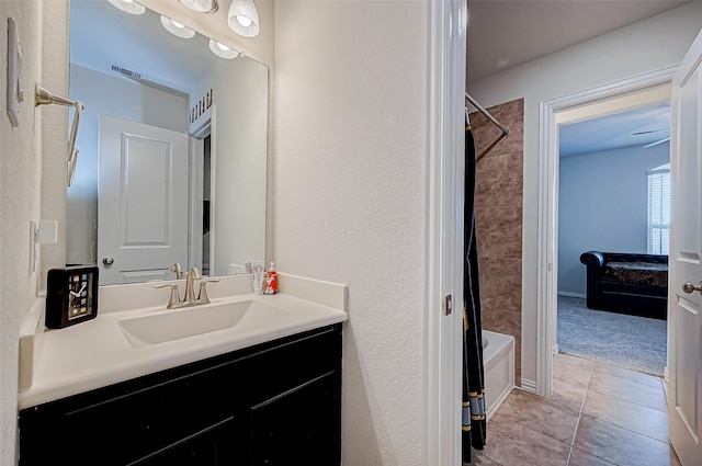 bathroom featuring tile patterned flooring, vanity, and tiled shower / bath combo