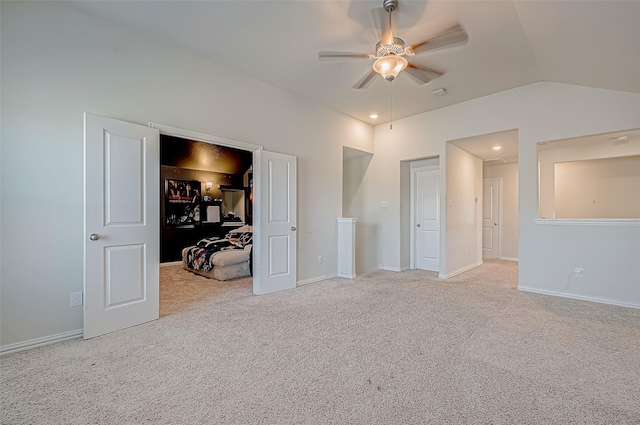 unfurnished bedroom with ceiling fan, light colored carpet, and lofted ceiling