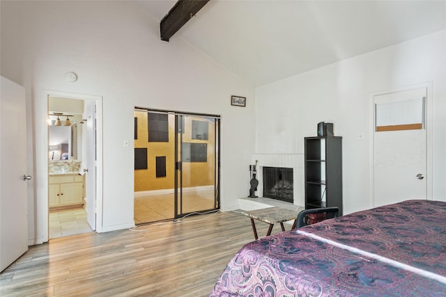 bedroom with ensuite bathroom, hardwood / wood-style floors, beamed ceiling, and high vaulted ceiling