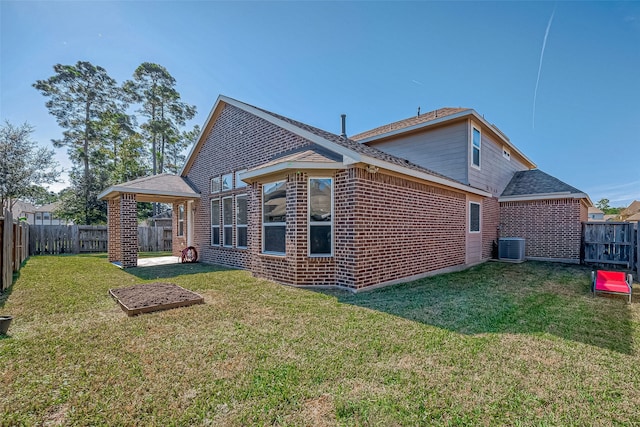 back of property with a lawn and central air condition unit