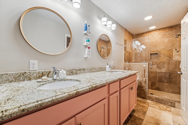 bathroom with vanity, an enclosed shower, and a textured ceiling