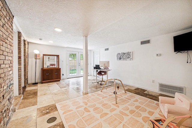 unfurnished room with brick wall and a textured ceiling