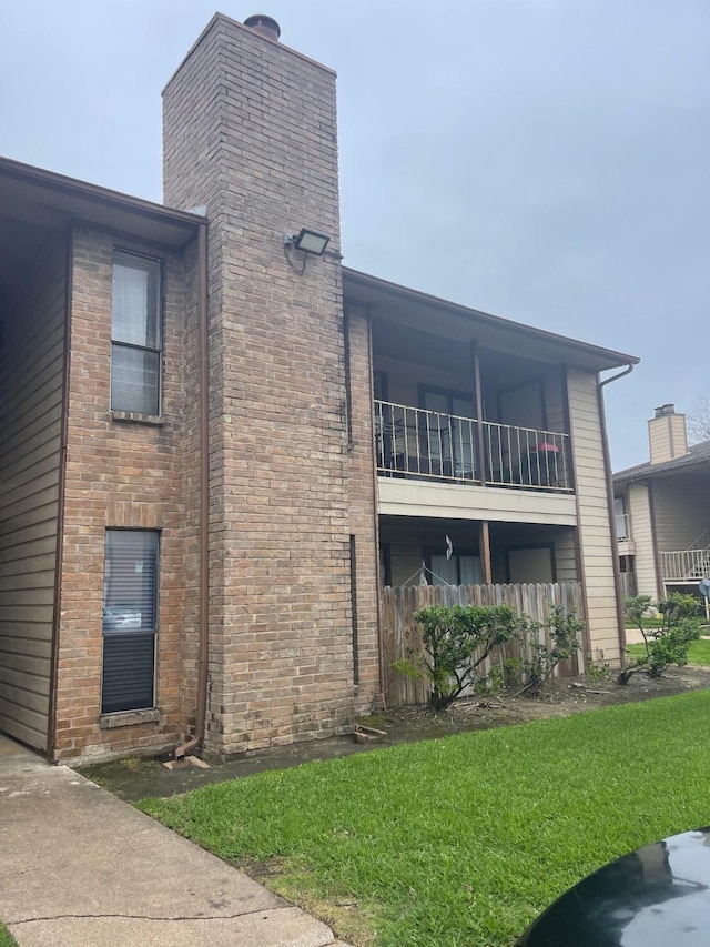 view of property exterior featuring a balcony and a yard