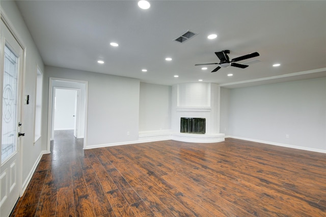 unfurnished living room featuring a fireplace, ceiling fan, and dark hardwood / wood-style flooring