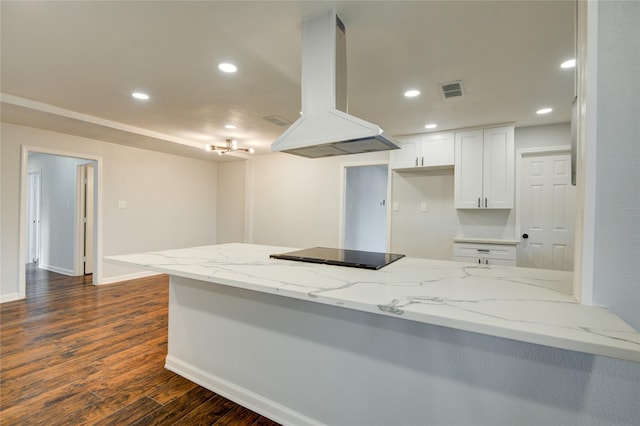 kitchen with white cabinets, island range hood, and kitchen peninsula