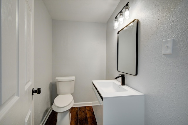 bathroom featuring wood-type flooring, vanity, and toilet