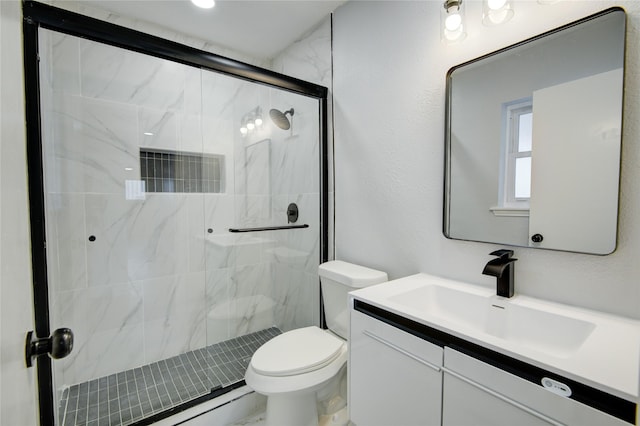 bathroom with vanity, toilet, and a shower with door