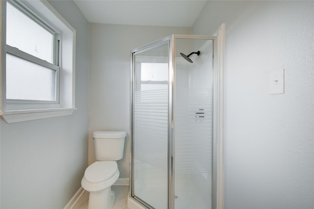 bathroom featuring toilet and a shower with shower door