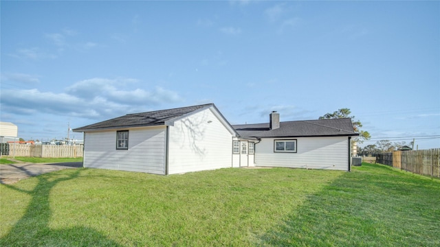 rear view of house featuring a yard and central AC unit