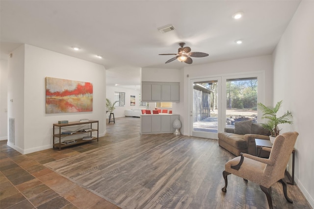 sitting room with ceiling fan and dark wood-type flooring