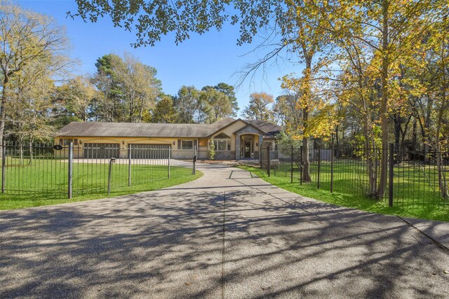 ranch-style house featuring a front yard and a garage