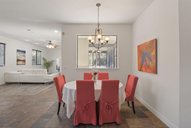 dining space featuring ceiling fan with notable chandelier