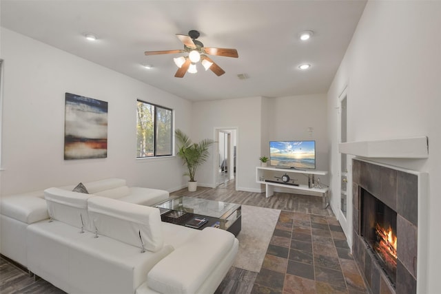 living room with ceiling fan, dark hardwood / wood-style floors, and a premium fireplace