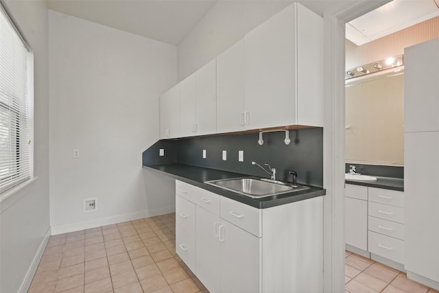 kitchen featuring white cabinets, light tile patterned floors, sink, and tasteful backsplash