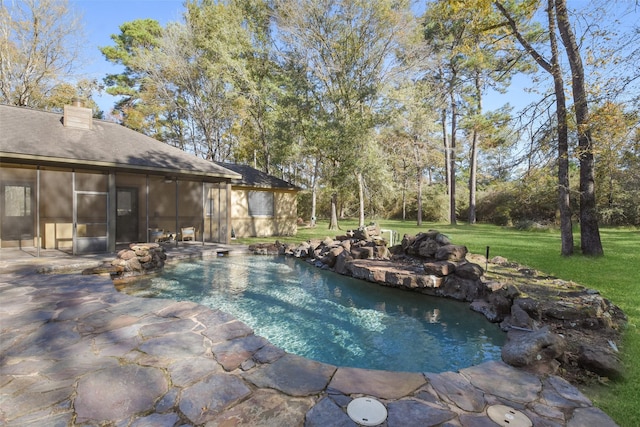 view of pool with a lawn and a sunroom