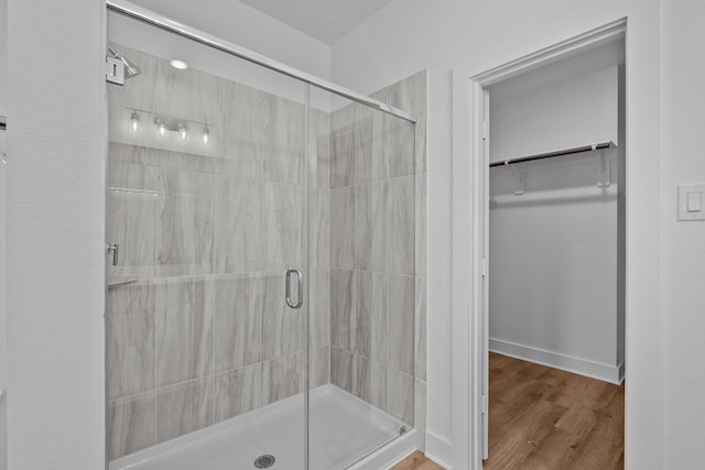 31915 Splendor Dr, Fulshear, TX 77441 - bathroom with a stall shower, a spacious closet, wood finished floors, and baseboards
