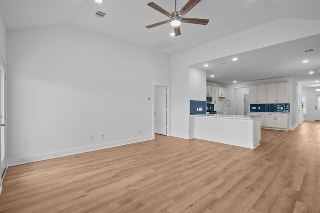 31915 Splendor Dr, Fulshear, TX 77441 - unfurnished living room with lofted ceiling, ceiling fan, light wood-type flooring, a sink, and recessed lighting