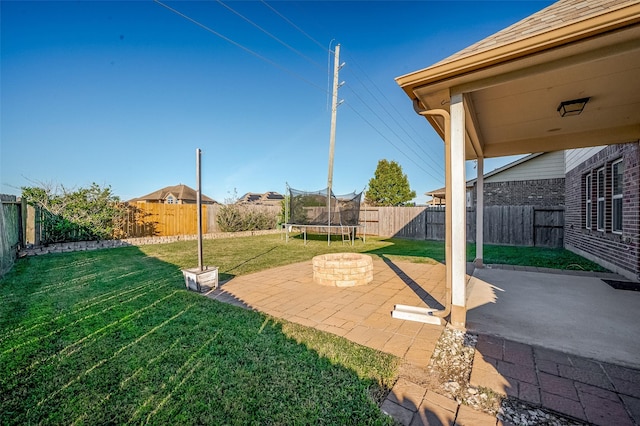 view of yard featuring a trampoline and a patio