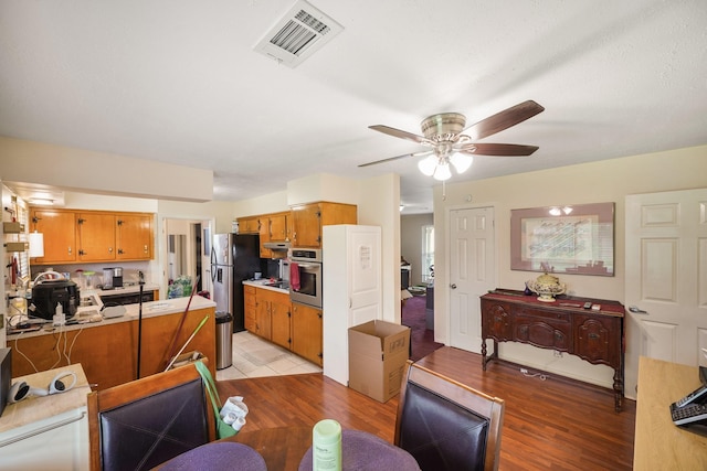 dining room featuring visible vents, light wood finished floors, and ceiling fan