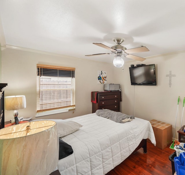 bedroom featuring ornamental molding, a ceiling fan, and wood finished floors