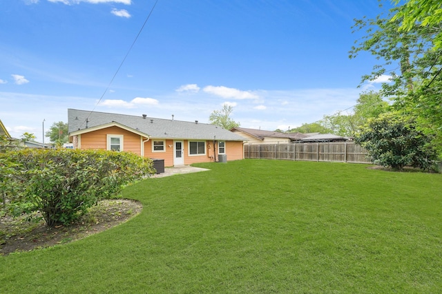 rear view of property featuring a lawn, a patio, and a fenced backyard