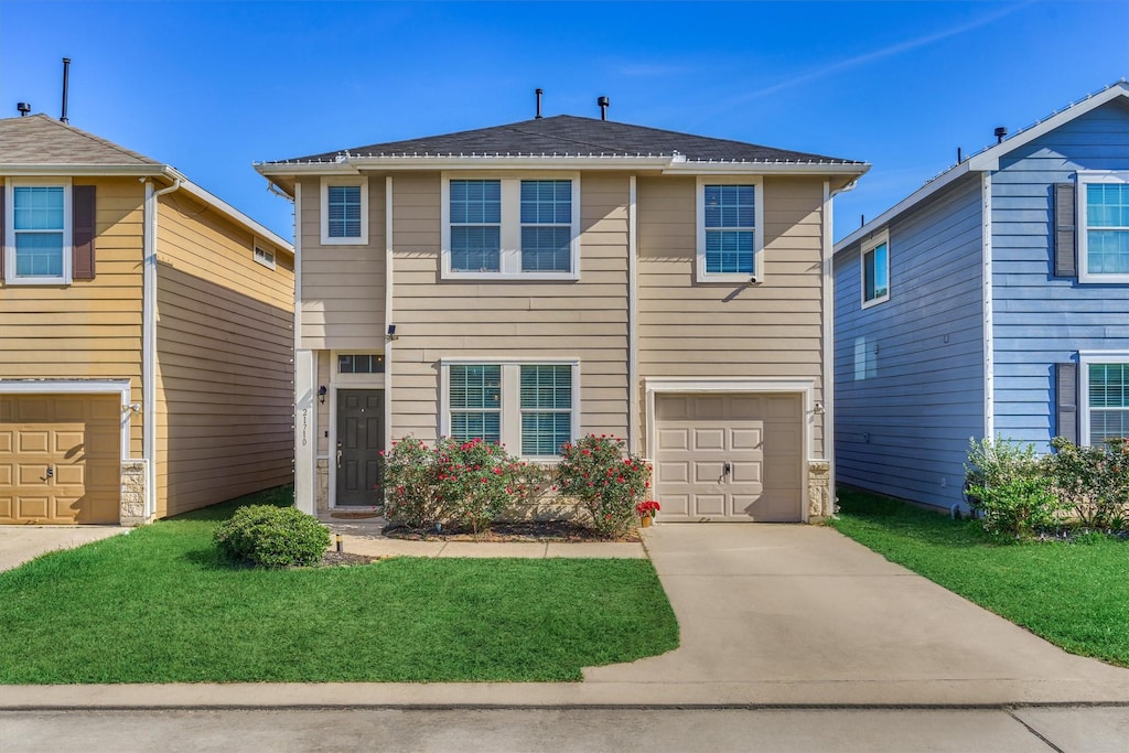 view of front of property with a garage and a front lawn