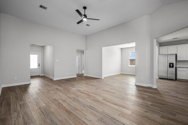 unfurnished living room featuring ceiling fan and light wood-type flooring