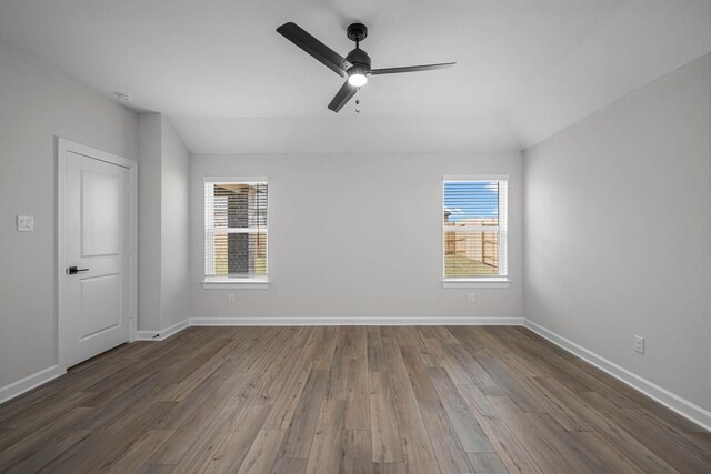 unfurnished room with ceiling fan, dark wood-type flooring, and a wealth of natural light