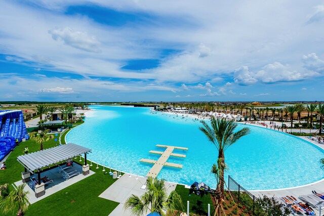 view of swimming pool with a yard and a water view