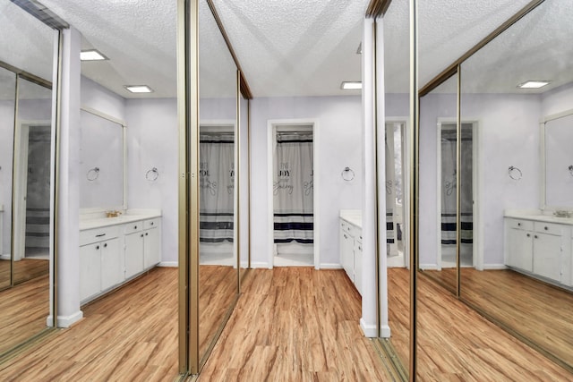 bathroom with hardwood / wood-style flooring, vanity, and a textured ceiling