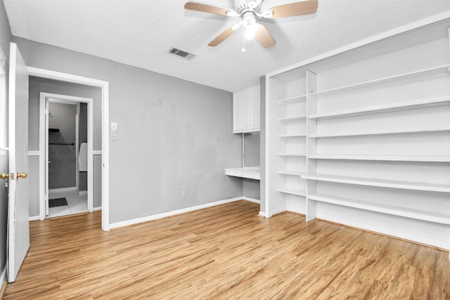 interior space with ceiling fan, light hardwood / wood-style floors, and a textured ceiling