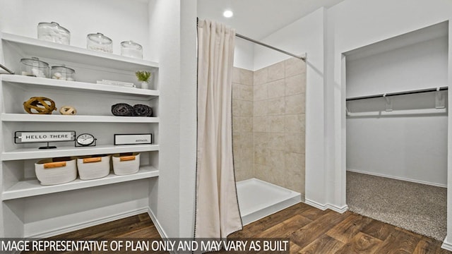 bathroom featuring hardwood / wood-style flooring and walk in shower