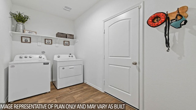 laundry area featuring washing machine and clothes dryer and wood-type flooring