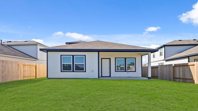 rear view of property featuring a lawn