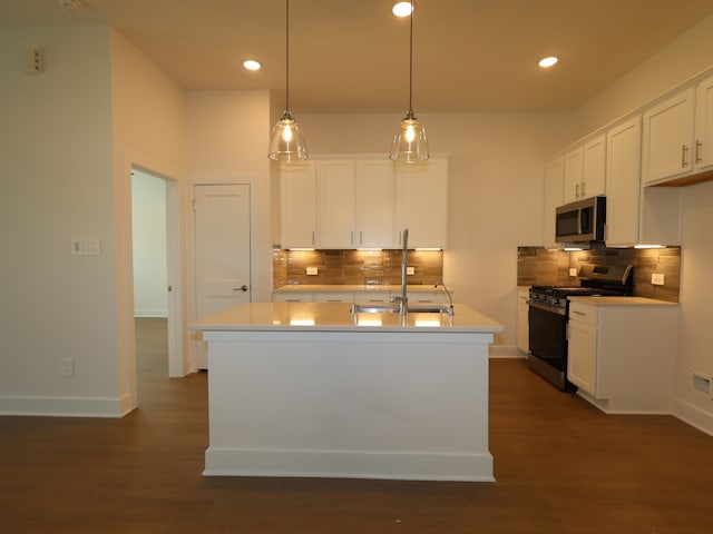 kitchen featuring white cabinetry, stainless steel appliances, decorative backsplash, and a sink