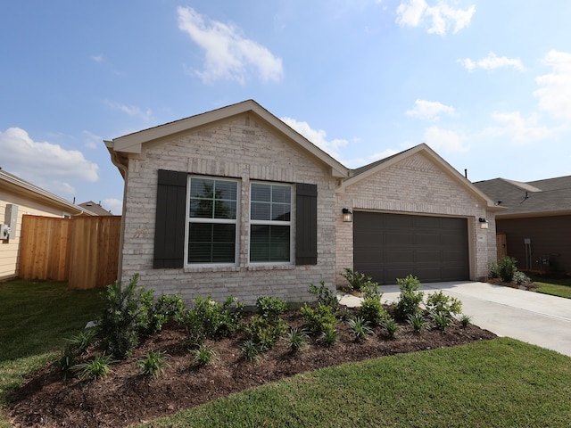 view of front of property with brick siding, fence, an attached garage, concrete driveway, and a front yard