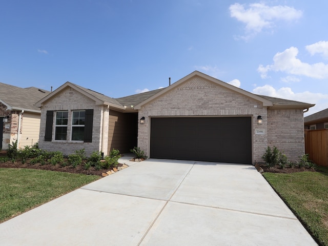 ranch-style home with a front yard, an attached garage, brick siding, and driveway