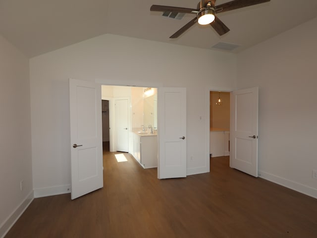 unfurnished bedroom with lofted ceiling, baseboards, dark wood finished floors, and a sink