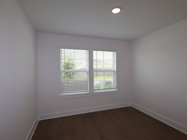 empty room with baseboards and dark wood-style floors