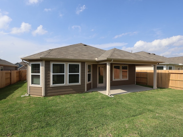 back of house featuring a fenced backyard, roof with shingles, a patio area, and a yard