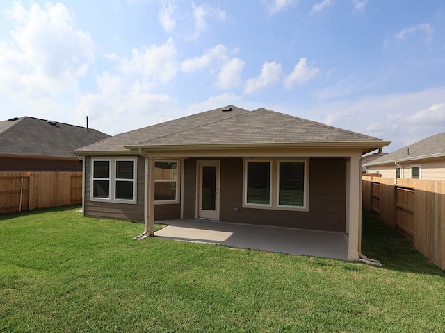 back of house featuring a yard, a patio, roof with shingles, and a fenced backyard