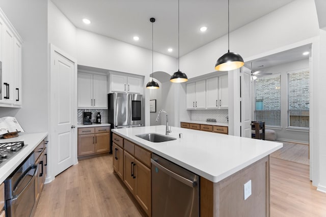 kitchen with pendant lighting, sink, an island with sink, and appliances with stainless steel finishes