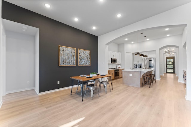 dining room with light wood-type flooring and a chandelier