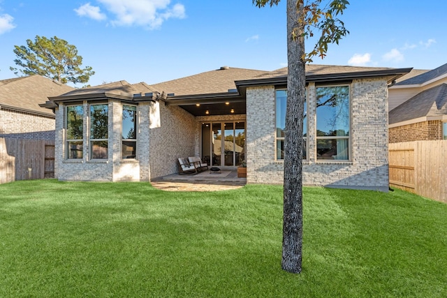 rear view of property with a yard and a patio