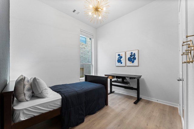 bedroom with light hardwood / wood-style flooring, vaulted ceiling, and a notable chandelier