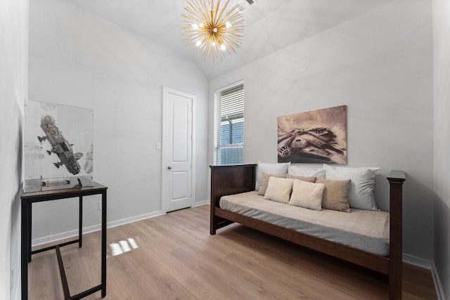 living area featuring lofted ceiling, wood-type flooring, and a chandelier