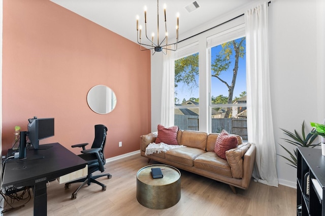 office space with light wood-type flooring and an inviting chandelier