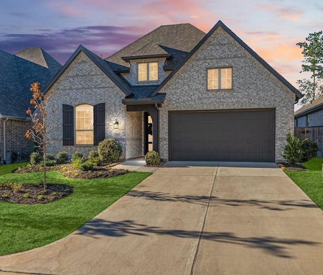 view of front of property with a yard and a garage