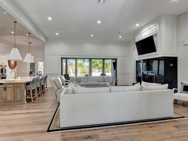 living room featuring sink and light wood-type flooring