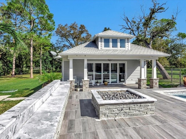 back of house featuring a lawn and a fire pit